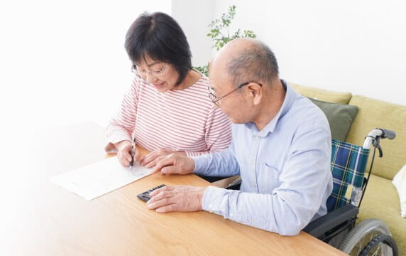 ソファで相続の相談をする年配のご夫婦と担当者