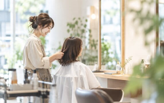明るい店内でお客様の髪を整える hair salon lull のスタイリスト