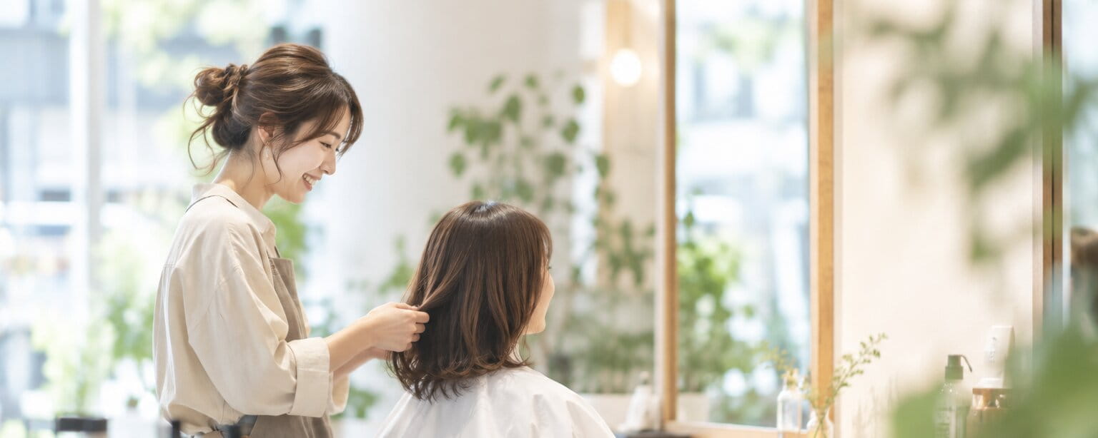 明るい店内でお客様の髪を整える hair salon lull のスタイリスト