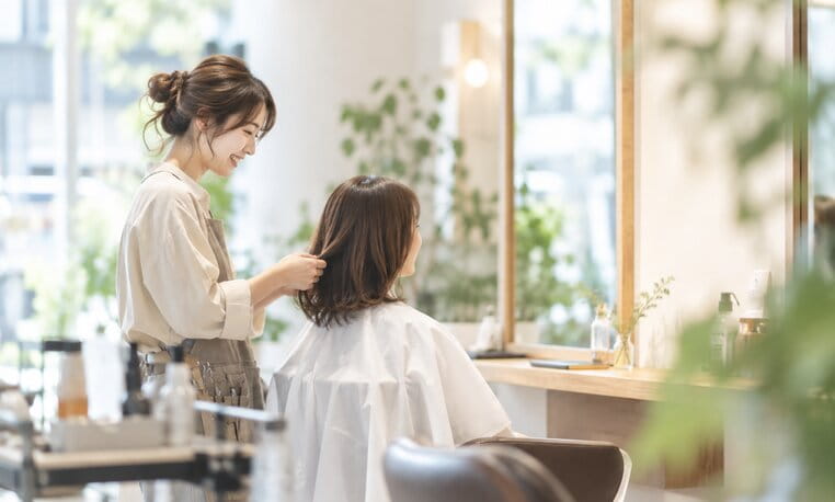 明るい店内でお客様の髪を整える hair salon lull のスタイリスト